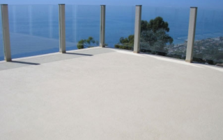 after concrete resurfacing deck with glass panels looking over the ocean