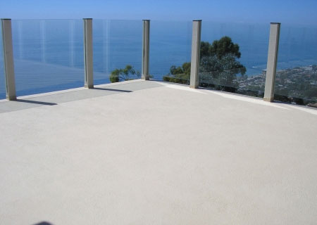 after concrete resurfacing deck with glass panels looking over the ocean