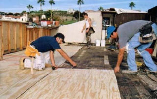 workman preparing surface for deck coating application