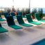 green lounge chairs on a beige pool deck coated with Orange County deck waterproofingcoatings