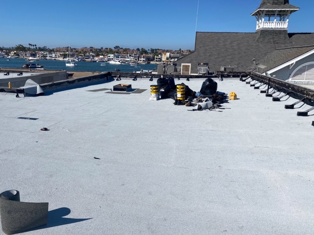 white flat roofs coating reflecting light by a harbor