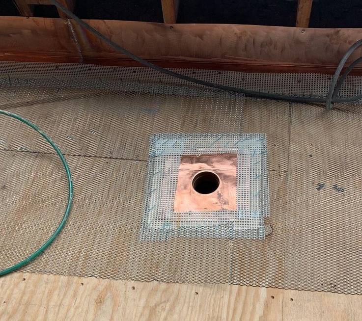 deck waterproofing project where copper flashing is covered with a fiber and cloth lath