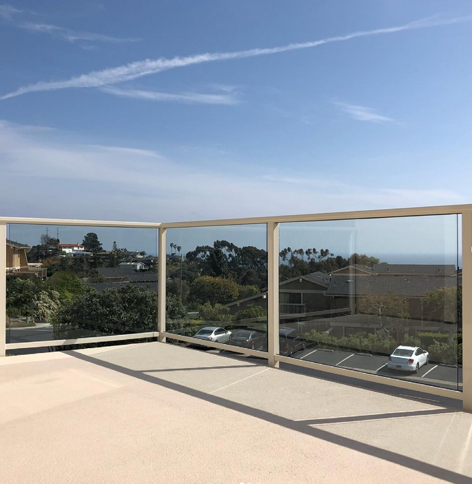 clear glass deck railings show view of ocean from beige deck