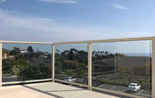 concrete resurfacing after with beige knockdown textured concrete and clear panel deck railing