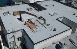 arial view of Newport Beach commercial building flat roof repairs and roof coatings application taken from drone