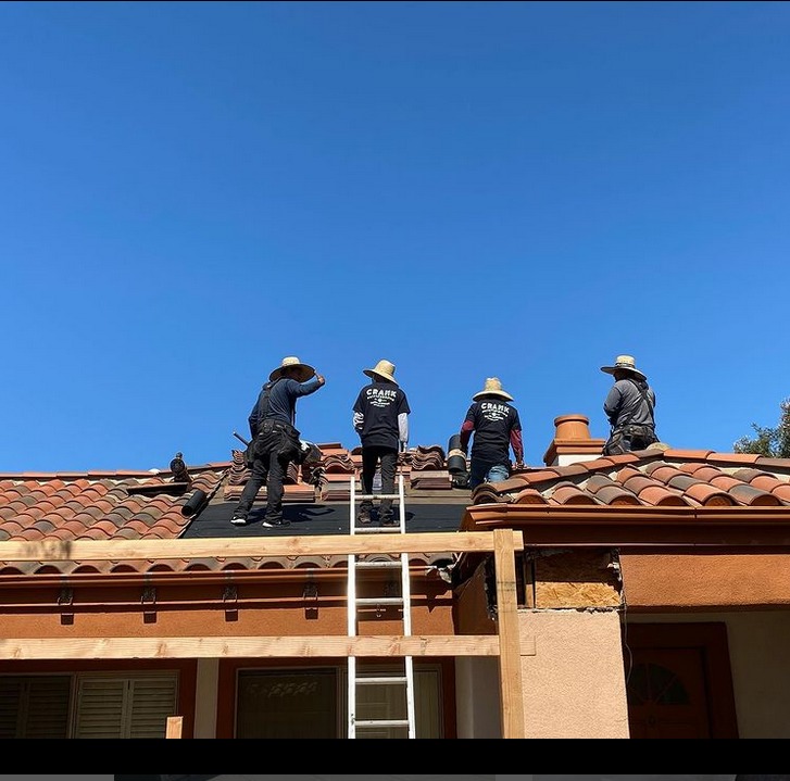 Men standing on roof during tile roof repair job