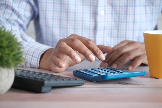 man hands with calculator figuring cost of concrete resurfacing