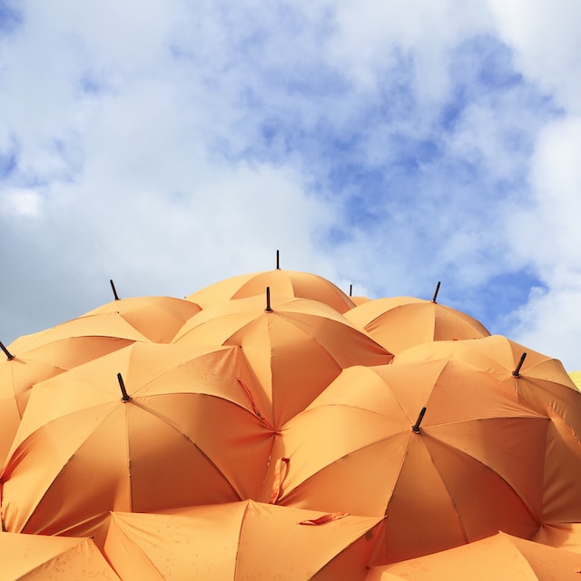 orange umbrellas and blue sky with white clouds