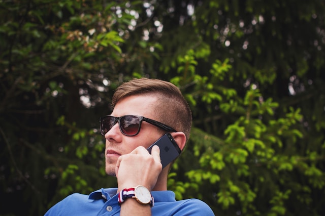 man in blue shirt talking on cell phone checking deck contractor references