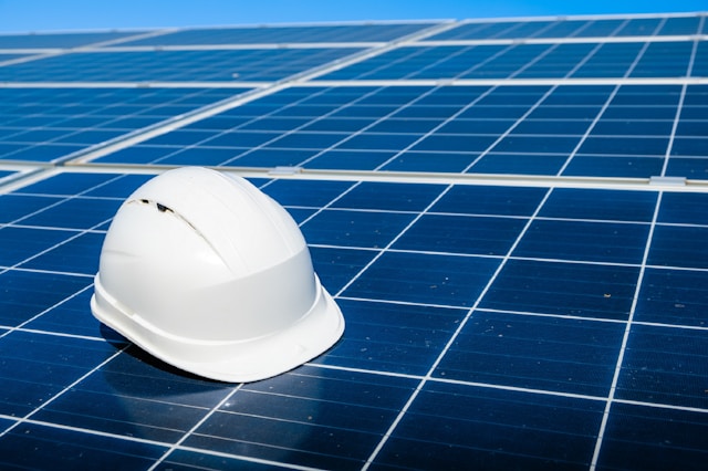 white hard hat on solar panels installed on flat roof