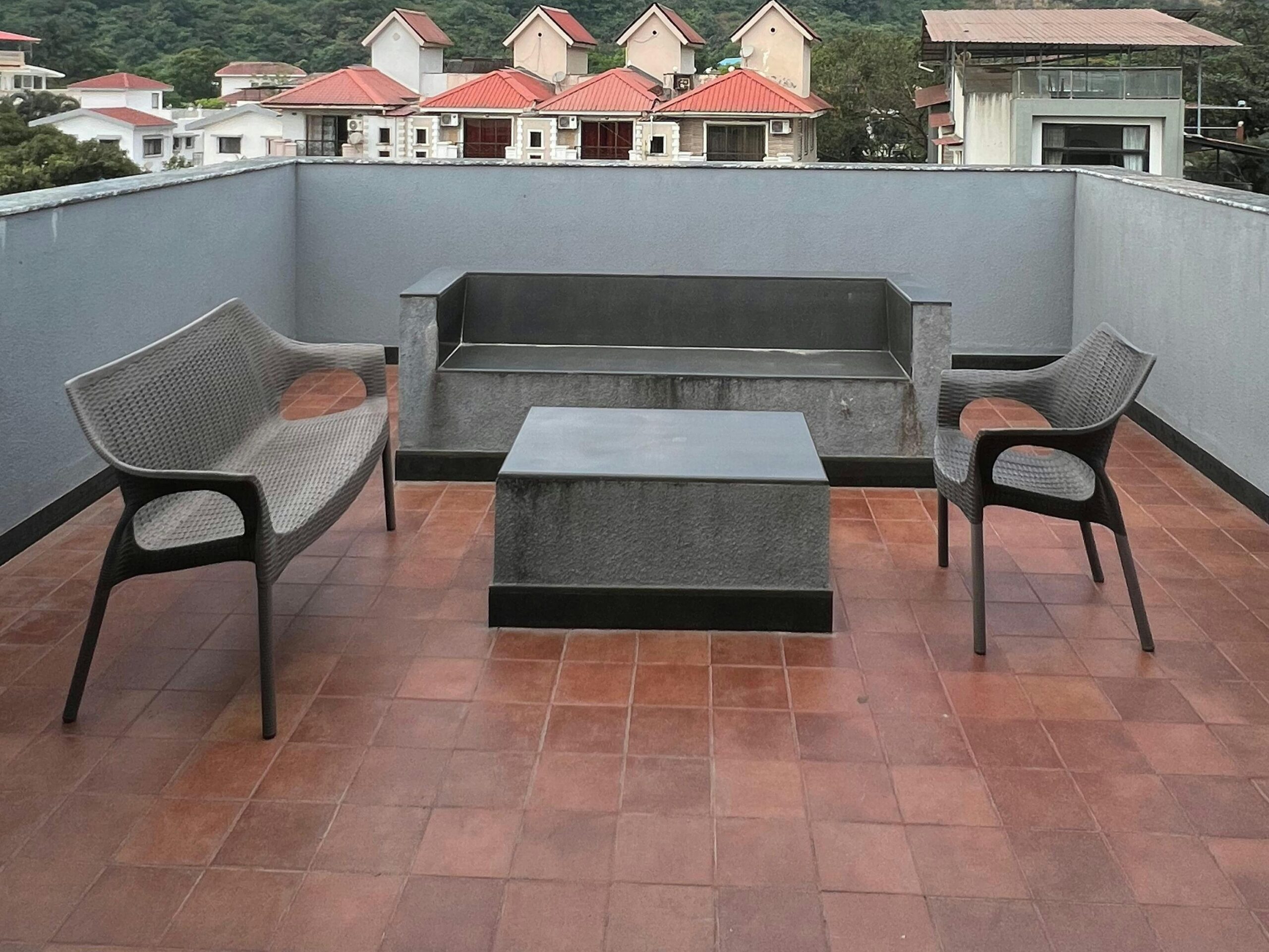 roof decks with house in back and couch and chair in front