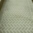 After concrete resurfacing with a walkway coating that creates a green herringbone brick pattern