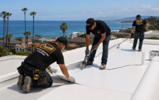 Crank workers in black tee shirts installing single ply TPO to Orange County flat roof