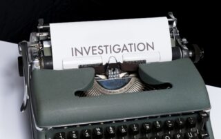 typewriter with paper and word investigation